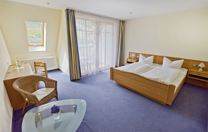 Ansicht der Juniorsuite mit Doppelbett und großer Fensterfront